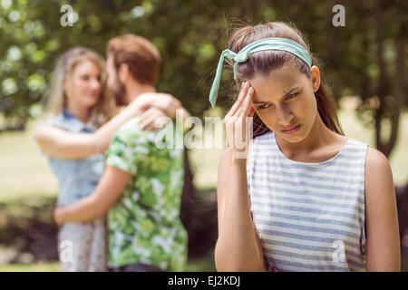 Brunette upset at seeing boyfriend with other girl Stock Photo