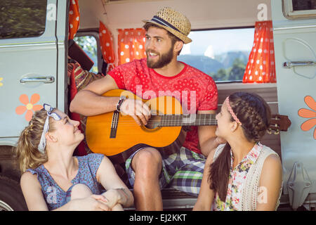 Hipster playing guitar for girls Stock Photo