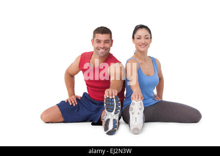 Fit man and woman stretching legs Stock Photo