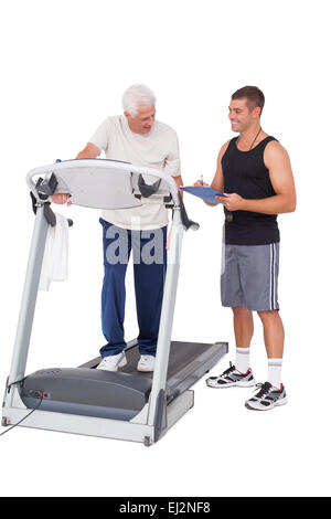 Senior man on treadmill with trainer Stock Photo