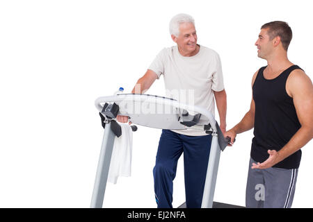 Senior man on treadmill with trainer Stock Photo