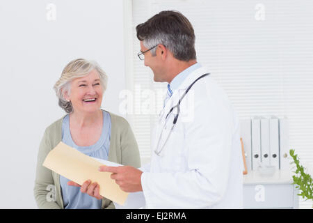 Doctor and patient conversing over reports Stock Photo