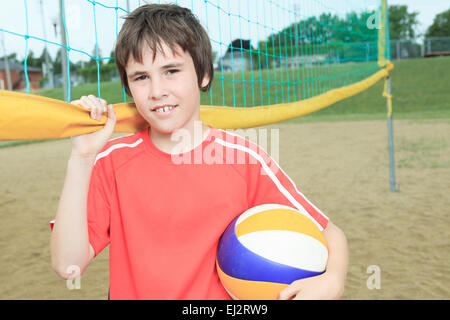 Portrait of happy family holding volleyball outside Stock Photo