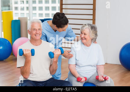 Female instructor with senior couple in gym Stock Photo