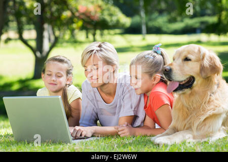 Happy family using laptop in the park Stock Photo