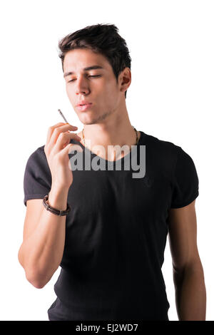Handsome young man looking at his cigarette, isolated on white background Stock Photo