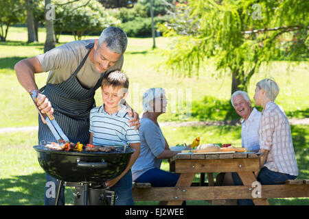 Happy father doing barbecue with his son Stock Photo
