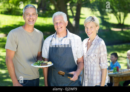 Happy couple with grandfather doing barbecue Stock Photo