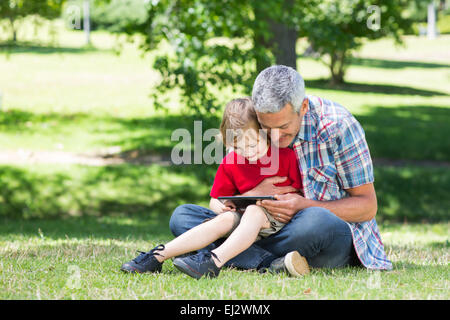 Happy father using tablet pc with his son Stock Photo