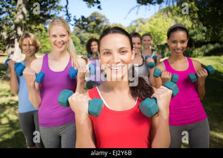 Fitness group lifting hand weights in park Stock Photo