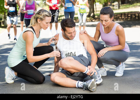 Man with injured ankle during race in park Stock Photo