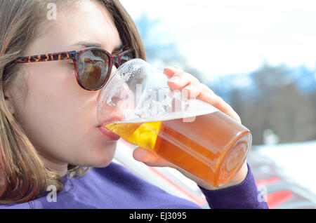 Young woman outdoors drinking a beer in sunglasses Stock Photo