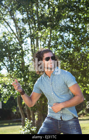Young man playing air guitar in the park Stock Photo