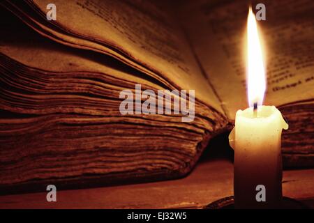 concept of knowledge, vintage book candle Stock Photo