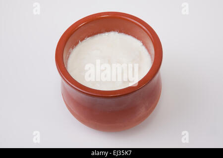 Homemade curd in clay pot made from cow milk. Isolated over white background Stock Photo