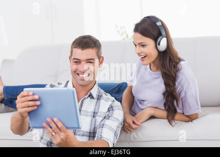 Man showing digital tablet to surprised woman Stock Photo