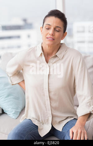 Sad woman suffering from backache at home Stock Photo