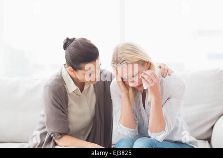 Patient crying next to her therapist Stock Photo