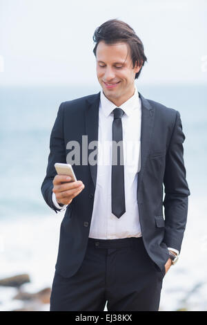 Smiling businessman using his smartphone Stock Photo