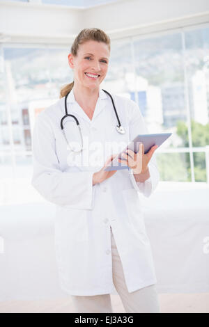 Smiling doctor using tablet pc Stock Photo