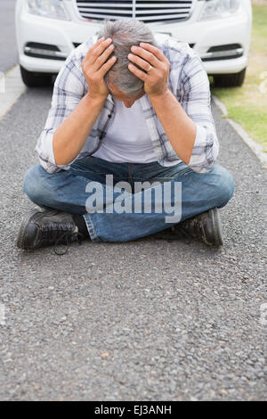 Stressed man sitting on the ground Stock Photo