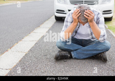 Stressed man sitting on the ground Stock Photo