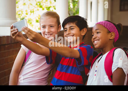 Happy kids taking selfie in school corridor Stock Photo