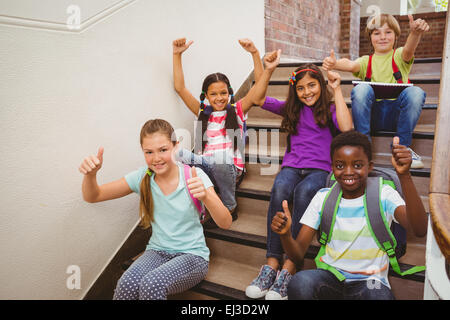 Children sitting on stairs in school Stock Photo