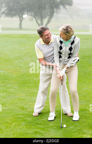 Golfing couple putting ball together Stock Photo