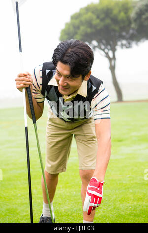 Golfer placing golf ball on tee Stock Photo