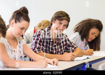 Students writing notes in classroom Stock Photo