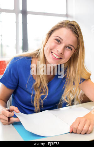 Female student writing notes in classroom Stock Photo