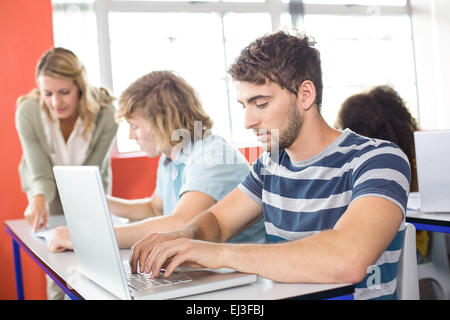 Student using laptop in classroom Stock Photo