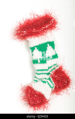 Knitted Christmas stocking with a Christmas tree pattern and red fluffy trim Stock Photo