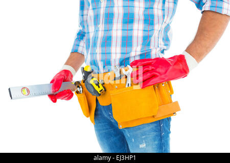 Midsection of handyman holding spirit level Stock Photo
