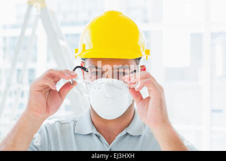 Handyman wearing protective eyewear at site Stock Photo