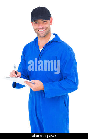 Handyman in blue overall writing on clipboard Stock Photo