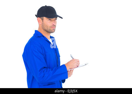 Mechanic in blue overalls writing on clipboard Stock Photo