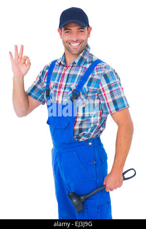 Portrait of happy plumber with plunger gesturing okay Stock Photo