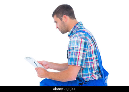 Handyman reading clipboard on white background Stock Photo