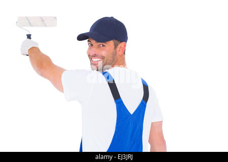 Portrait of handyman in overalls using paint roller Stock Photo
