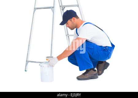 Side view of handyman with paint can on white background Stock Photo