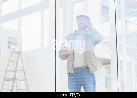 Architect using mobile phone in office Stock Photo