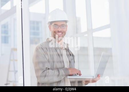 Smiling male architect using laptop in office Stock Photo