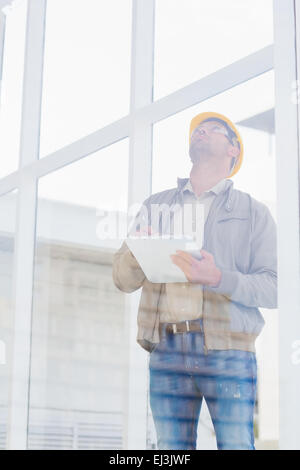 Supervisor looking up while writing on clipboard Stock Photo