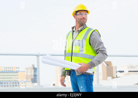 Architect holding rolled up blueprints outdoors Stock Photo