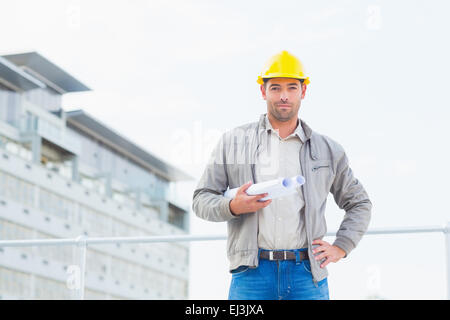 Confident architect with blueprints outdoors Stock Photo