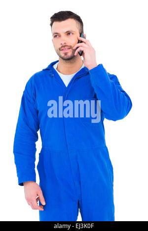 Smiling male mechanic using mobile phone Stock Photo