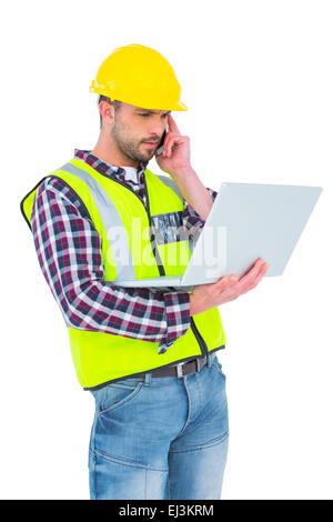 Handyman on the phone holding laptop Stock Photo