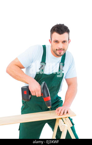 Carpenter drilling hole in plank Stock Photo